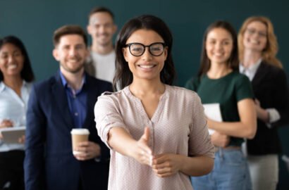 istockphoto-1201798767-612x612 Mixed race woman sales manager stretch out hand introduces herself greeting shake hands client smiling look at camera pose indoors with diverse teammates. HR, job interview, business etiquette concept